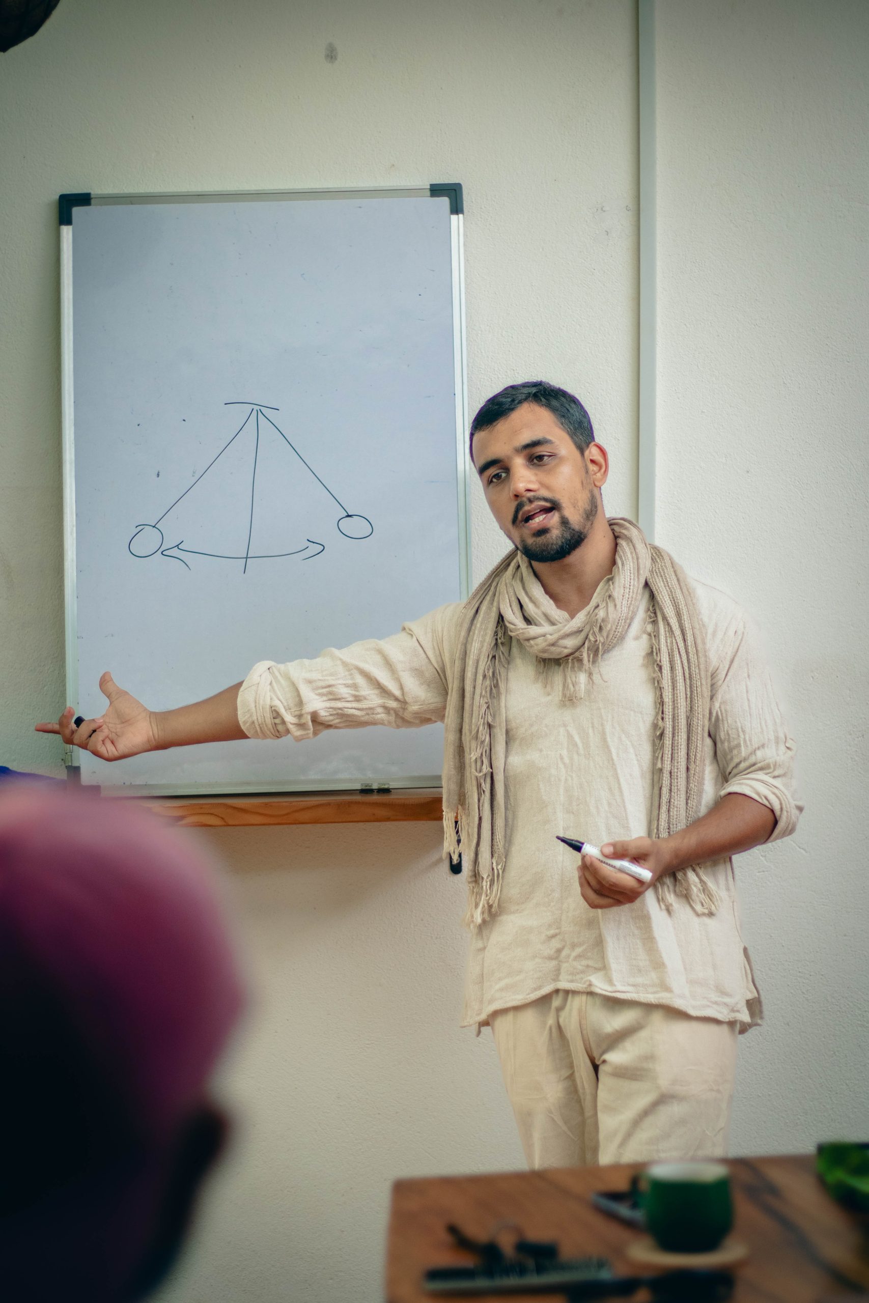 Himanshu Bisht teaching in front of a whiteboard with a hand-drawn diagram